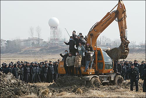 15일 오전 평택 미군기지 확장 예정지에서 주민들과 인권활동가들이 논을 파헤치는 포크레인을 점거하고 농성을 벌이고 있다. 